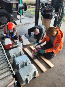 The team painting the cylinder head covers in gloss. Photo by James Whincup