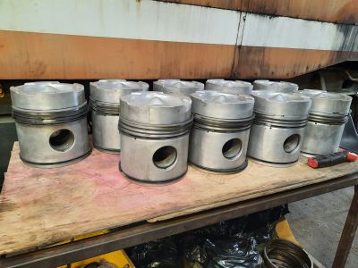 The table with a number of pistons with their new rings fitted. Photo by James Whincup